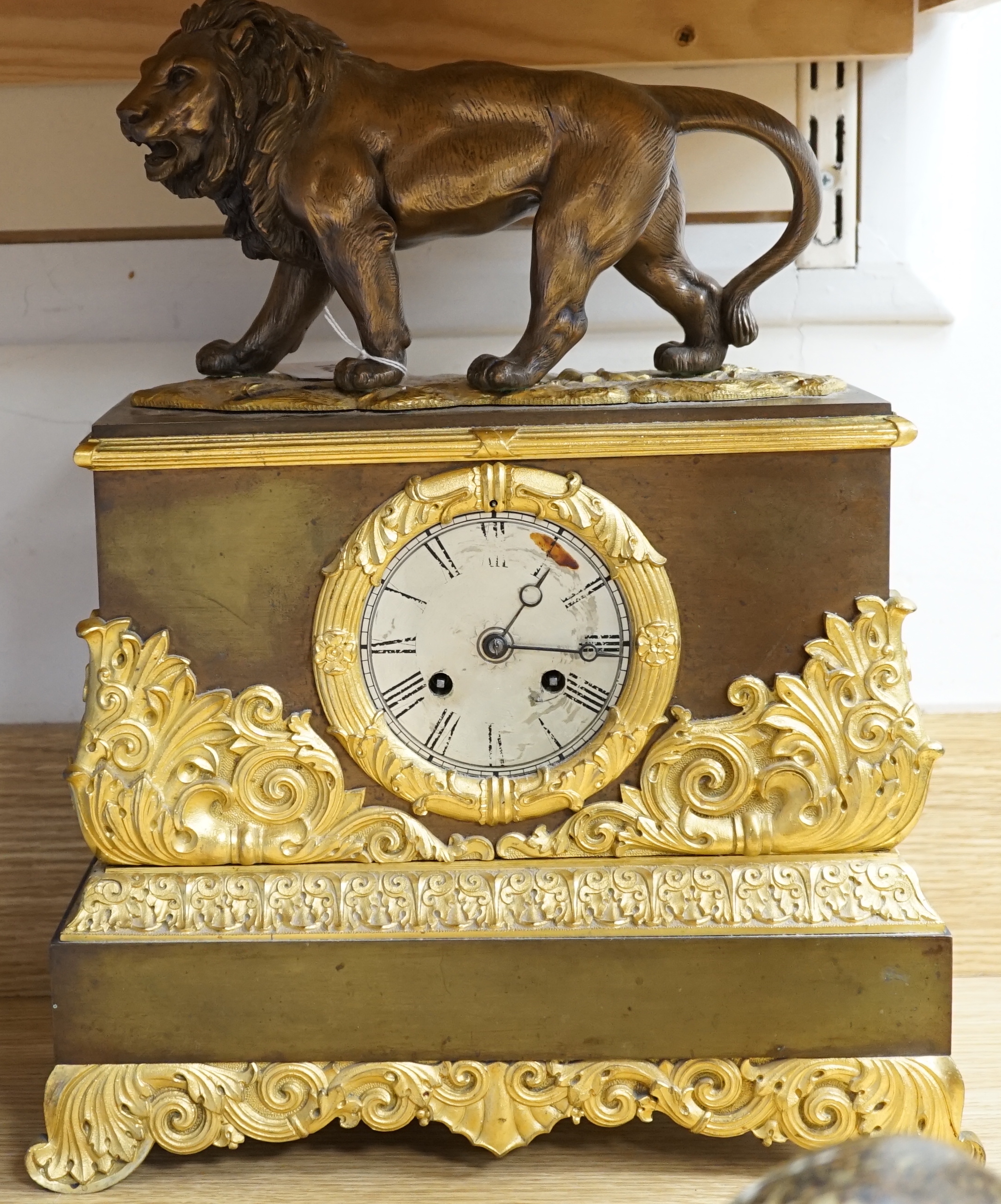A French gilt mounted lion mantel clock with a silk suspension movement striking on a bell, 43cm high